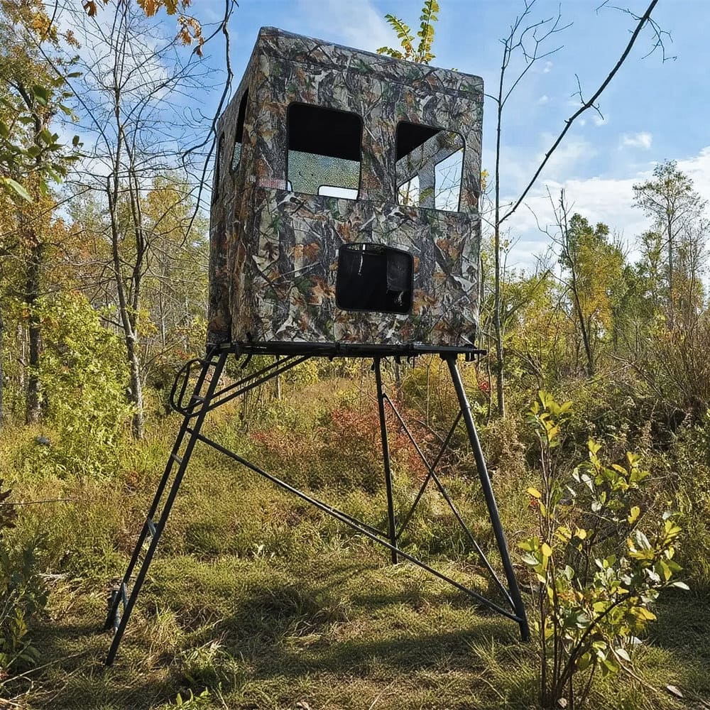 Camouflage hunting blind on a stand in a forest setting